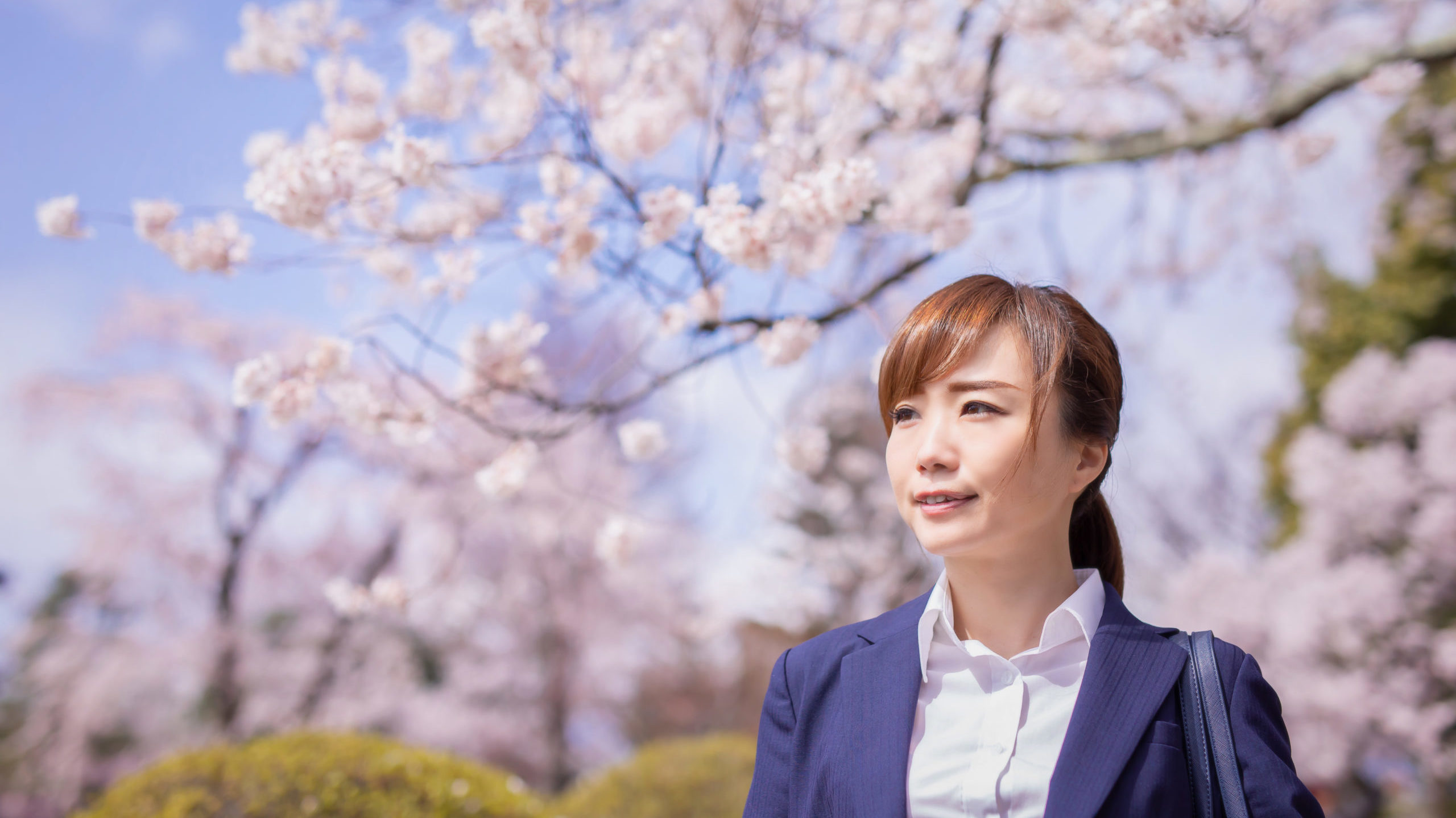 桜とスーツ姿の女性